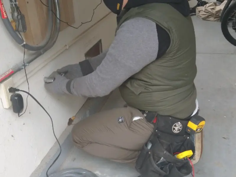 Electrician performing outlet wiring in a Moonachie garage
